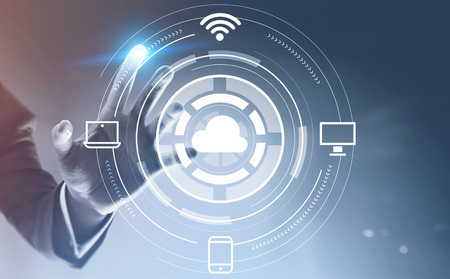 Hand of businessman using cloud computing interface with hud over gray blue background. Hi tech in...