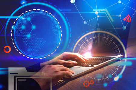 Hands of businessman wearing a black shirt typing on his laptop over dark blue background with...
