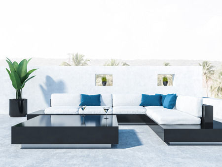 Balcony of a luxury house with black and white sofas, blue cushions and black coffee table. Close up. Tropical view in background. 3d renderingの写真素材