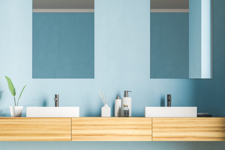 White angular double bathroom sink standing on wooden countertop with rectangular mirrors above it in blue wall room. 3d renderingの写真素材