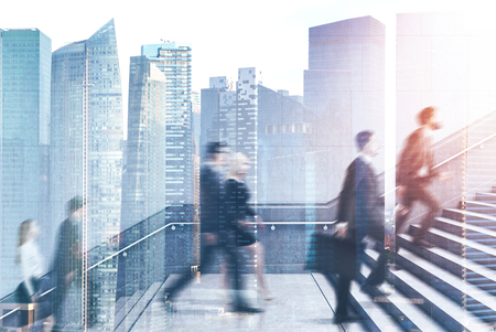 Businessmen and businesswomen climbing stairs with city double exposure. Concept of career ladder and business success. Toned imageの写真素材