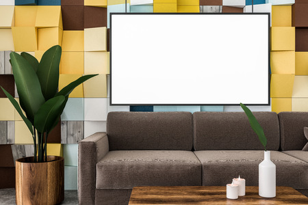 Close up of colored tiles wall living room interior with concrete floor, brown sofa, and coffee...