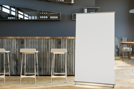 Interior of bar with gray walls, wooden floor, gray wooden bar and rows of stools. Bottles on the...