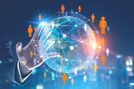 Hand of businessman touching Earth hologram with people network over night cityscape background. Toned image double exposure.の写真素材