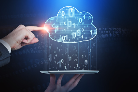 Man hand holding tablet another hand is touching cloud computer hologram causing it to rain binary...