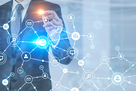 Unrecognizable businessman in dark suit and gray tie using business plan interface standing in his office. Toned image double exposureの写真素材