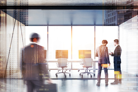 Business people in open space office with panoramic windows, wooden and white walls, wooden floor and long white computer table with monitors. Glass door. Toned image double exposure blurredの写真素材
