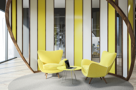 Modern office waiting area with gray walls, wooden floor, and yellow armchairs standing near round coffee table with laptop. 3d renderingの写真素材