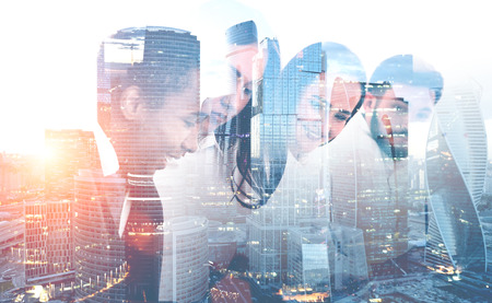 Four members of diverse business team brainstorming over morning cityscape background. Concept of business lifestyle. Toned image double exposureの写真素材