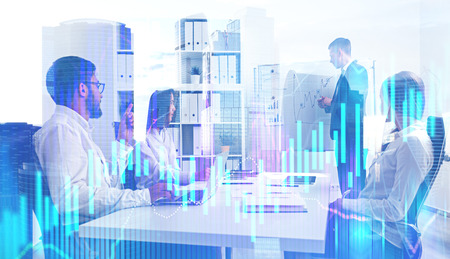 Business team making a presentation in their office with double exposure of modern cityscape and graph in the foreground. Toned image Business team making a presentation in their office with double exposure of modern cityscape and graph in the foreground. Toned image