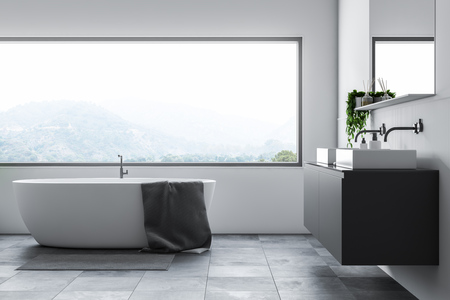 Interior of bathroom with white walls, tiled floor, white tub standing under big window and double sink on gray countertop. 3d renderingの写真素材