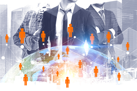 Three confident businessmen standing with crossed arms over cityscape background with Earth and global people network hologram.の写真素材