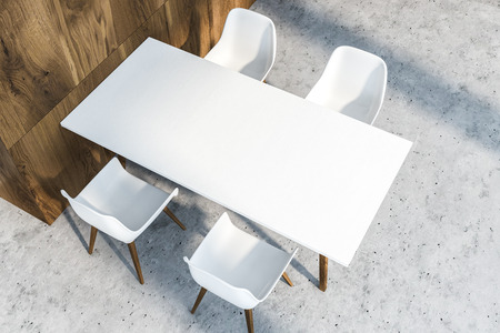 Top view of white dining table with four chairs standing in dining room with wooden walls and stone floor. 3d renderingの写真素材