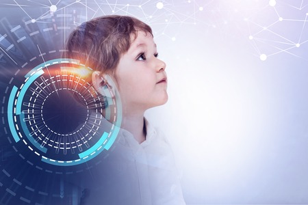 Portrait of adorable little boy wearing white shirt standing against gray background with double exposure of immersive hud interface. Toned image mock upの写真素材