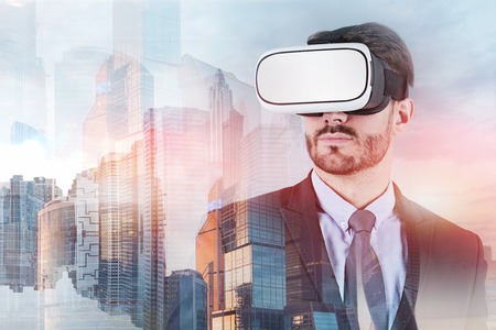 Bearded businessman wearing vr glasses and suit standing over Moscow city background. Hi tech...