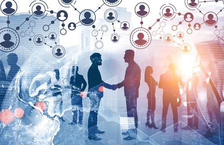 Silhouettes of business people shaking hands and working over cityscape background with people...