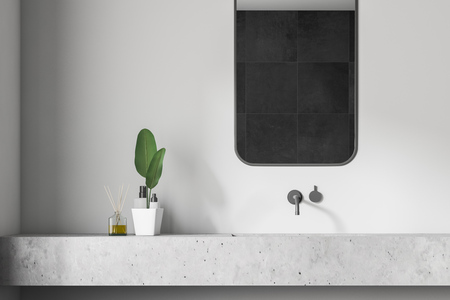 Close up of bathroom sink made of white stone with vertical mirror above it standing in room with white walls. 3d renderingの写真素材