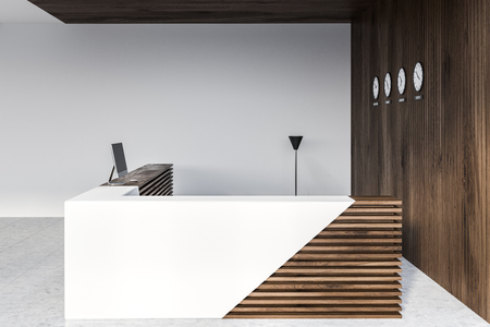 Corner of modern office with white and wooden walls, tiled floor and white and wooden reception table with computer and clocks on the wall. 3d renderingの写真素材