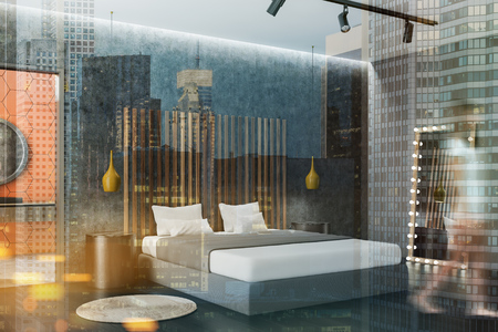 Woman in corner of bedroom with concrete and gray walls, dark wooden floor, gray master bed with round bedside tables and vertical mirror and open bathroom door. Toned image double exposure blurの写真素材