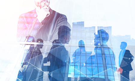 Unrecognizable pensive businessman with double exposure of his team members over cityscape background. Concept of management. Toned imageの写真素材