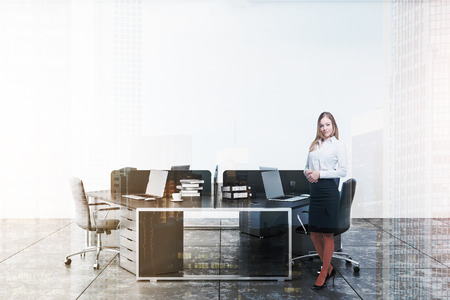 Woman in interior of minimalistic office with white walls, gray tiled floor and original hexagonal computer table with laptops on it. Toned image double exposureの写真素材