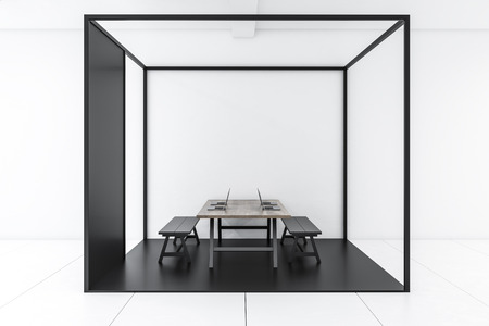 Interior of modern office with white walls, tiled floor, long wooden computer table with black benches standing inside black cube. 3d renderingの写真素材
