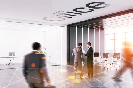 Businessmen in interior of modern office with white, gray and glass walls, concrete floor, office room with massive table and computers on it and manager room. Toned image double exposure blurの写真素材
