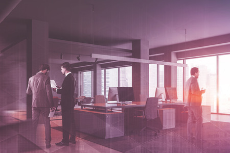 Businessmen in interior of panoramic office with gray walls, concrete floor, gray computer tables and meeting room in the background. Toned image double exposureの写真素材
