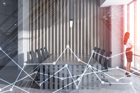 Businesswoman in interior of office conference room with concrete and wooden walls, concrete floor, large window and long gray table with black chairs. Toned image double exposureの写真素材