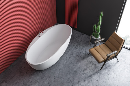 Top view of minimalistic bathroom with red and black walls, concrete floor, loft window, large comfortable white bathroom and leather armchair. 3d renderingの写真素材