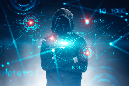 Unrecognizable hacker in black hoodie standing with crossed arms over dark blue background with immersive binary interface and HUD. Toned image double exposureの写真素材