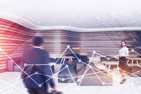 Beautiful businesswoman and African American businessman standing in wooden office lounge with poufs and tables. Graphs in foreground. Concept of stock market. Toned image double exposureの写真素材
