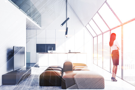 Woman looking in window of comfortable studio flat with kitchen and living room areas. Concept of interior design. Toned image double exposureの写真素材