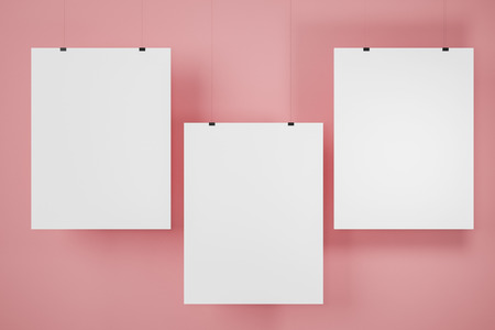 Three vertical mock up pictures hanging on pink wall. Concept of advertising and marketing. 3d renderingの写真素材