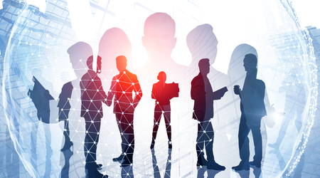 Silhouettes of business people over skyscraper background with planet hologram. Concept of teamwork and globalization. Toned image double exposureの写真素材
