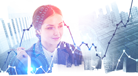 Thinking young businesswoman portrait over abstract city background with graphs and HUD interface. Financial analysis concept. Toned image double exposureの写真素材