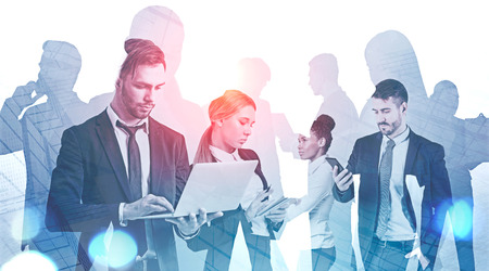 Group of business people working with gadgets and documents over skyscraper background....