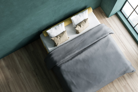 Top view of minimalistic bedroom interior with green walls, wooden floor and yellow master bed with pillows and gray blanket. 3d renderingの写真素材