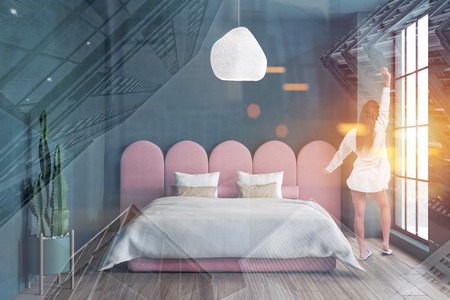 Woman in nightgown standing in stylish minimalistic bedroom with dark green walls and original pink master bed. Toned image double exposureの写真素材