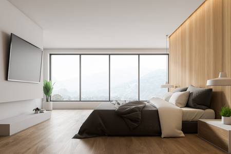 Interior of master bedroom with large window, wooden and white walls, wooden floor, gray king size bed with bedside table and big TV on the wall. 3d renderingの写真素材
