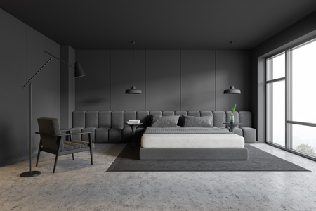 Interior of loft bedroom with gray walls, stone floor, master bed standing on gray carpet and armchair with floor lamp near it. 3d renderingの写真素材