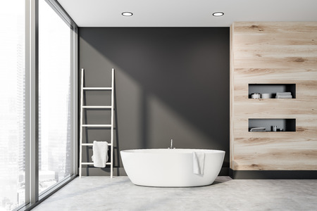 Interior of panoramic bathroom with gray and wooden walls, concrete floor, white bathtub with ladder...