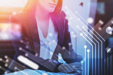 Businesswoman typing in office. Double exposure of circuit interface. Concept of technology and telecommunication in business. Toned imageの写真素材