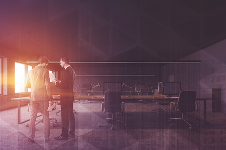 Business people discussing documents in modern open space office with gray walls and long computer tables with chairs. Toned image double exposureの写真素材