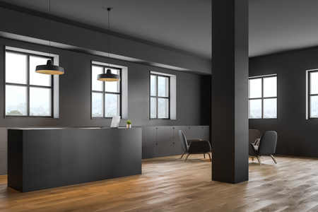Gray reception desk with computer on it standing in modern gray office with columns, file cabinets and lounge area with armchairs. 3d renderingの写真素材