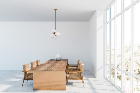Side view of panoramic dining room with white walls, concrete floor, dark wooden table with armchairs and stylish lamp. 3d renderingの写真素材