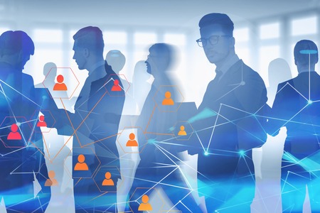 Business people walking and discussing documents in blurred office with double exposure of social media icons and network hologram. Concept of HR and hi tech. Toned imageの写真素材