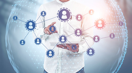 Businessman in white shirt using tablet computer with double exposure of social network and planet...