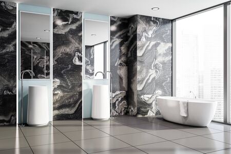 Corner of luxury bathroom with black marble walls, tiled floor, comfortable white bathtub with towel...