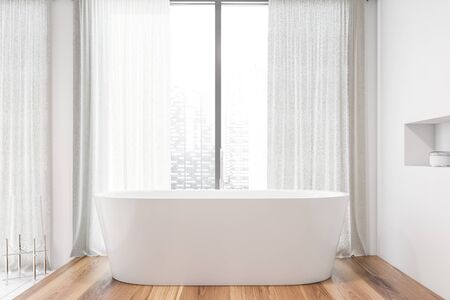 Interior of stylish bathroom with white walls, wooden floor, panoramic window with curtains and comfortable white bathtub standing near it. 3d renderingの写真素材